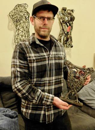 Holding the first scrap metal sculpture he made from discarded race car scraps