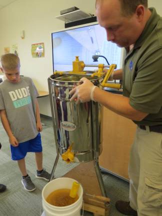 Mang shows his elementary school students how an extractor works.