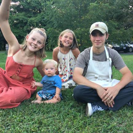 From left, siblings Esme, 14; Sigh, 9; Jonah, 17; and Zeke at 9 months, helping their mom make cheeseboards at a wedding in 2019.