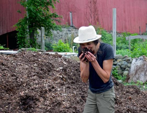 Berman smells the rich leaf humus of the compost heap: This is my favorite thing on the farm.