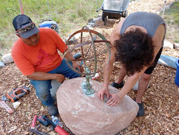 Pollination Meadow unveils children’s sundial and new trail Eagle Scout candidate Leo Portanova works with Mark Olson of M.P. Olson Excavation, who donated his time, equipment and the boulder upon which the sundial is mounted.