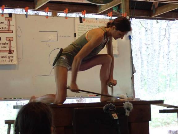 Instructor Carmen Corradino demonstrates how to make a fire using a bow drill. She later did it again using wrapped rootlets as her bow, in lieu of manmade rope.