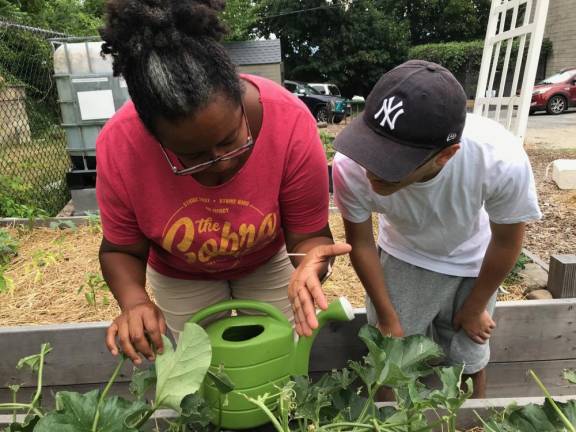 Christine Hutchinson with an OurCore student discussing plant care in the garden.