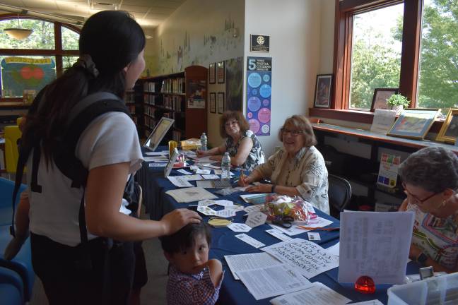 Script is far from dead A mom stops by the calligraphy pop-up at the Pike County Public Library in Milford, PA to get bookmarks with her kids’ names on them. Guild members, from left: Ann Marie Castelgrande, Annmarie Margotta and President Stephanie Cavallero.
