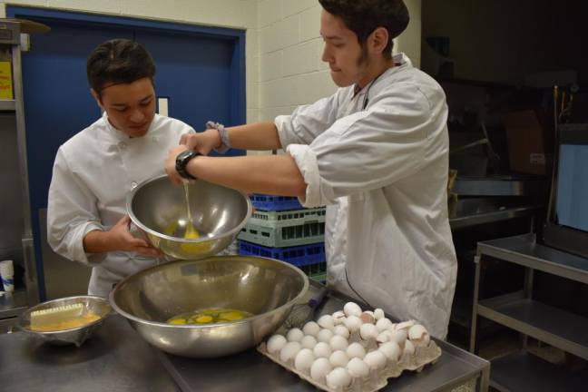 Josh Maroles, 15, cracking eggs for scrambled eggs, which he and his classmates will eat for breakfast. He works at Planet Pizza and wants to become a chef.