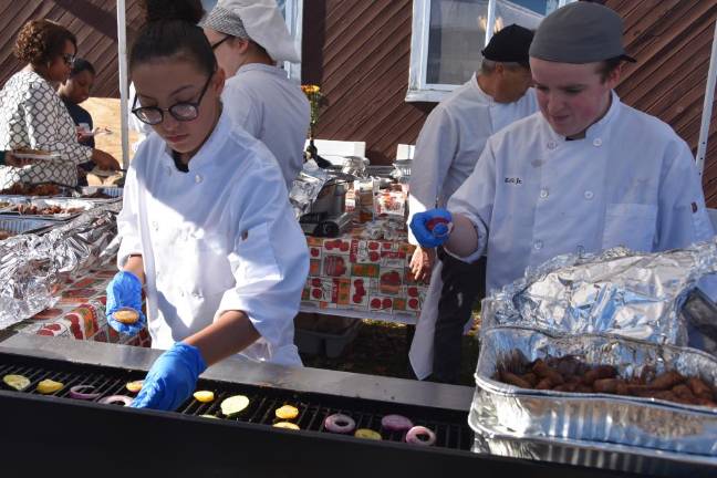 Chloe Argueta, 15, and Keith Grunenberg grill up veggies while fellow student Ashley Bonner keeps the self-serve line running smoothly.