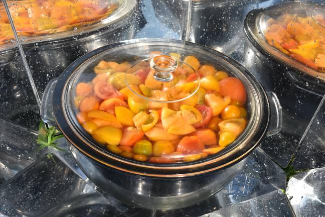 Fifty quarts of summer Tomatoes in the solar cooker, on their way to becoming a pantry staple.