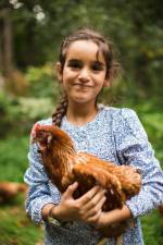 Malaak, 7, holding a hen
