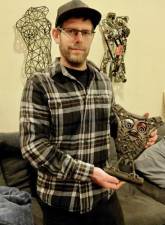 Holding the first scrap metal sculpture he made from discarded race car scraps