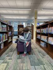 The writer’s kids reading the old fashioned way at the Goshen Public Library.