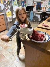 Juno, 9, turns venison into ground meat.