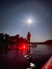 Joe Gara paddleboarding the Delaware on his first Full Moon Float in August.