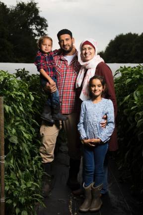 Samer Saleh and Diane Aboushi with kids Malak, 7, and Noah, 2, among the pepper plants