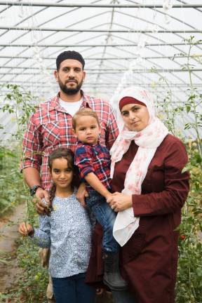Samer Saleh and Diane Aboushi with kids Malak, 7, and Noah, 2, among the cherry tomato plants