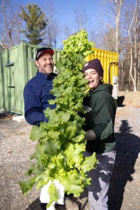 Amend and Licurse pose with lettuces ready to harvest. Come winter in the Northeast, said Amend, “there is no availability for local leafy greens and lettuces. It’s all coming from South America or Central America or Mexico, Calfornia, Florida.”