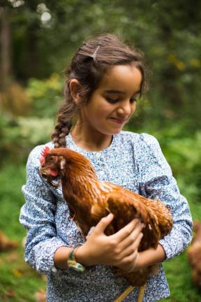 Malaak, 7, holding a hen