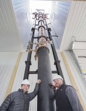 Jeremy Kidde (left) and Jason Grizzanti (right) co owners of the Black Dirt Distillery in Pine Island stand next to their newly installed 60 foot tall whiskey still on Thursday afternoon November 29, 2012