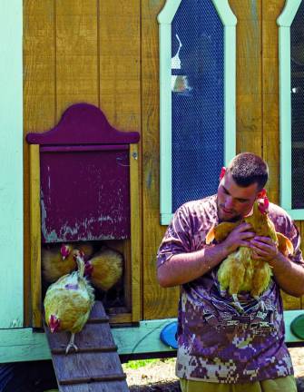 Justin M., 18, a student at The Center for Discovery, with a laying hen. Photo by Jesse Wall