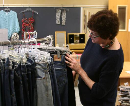 Mimi Fader, of Warwick, volunteers at the Hope Chest, organizing a rack of jeans. Photo by Raheli Harper.