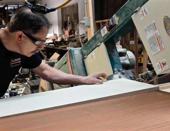 Ray Negron feeds the felt into the band saw