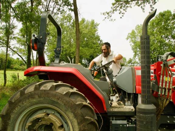 Yisroel Bass on his tractor. He harvests and mills his organic wheat and spelt to make matzo for Passover.