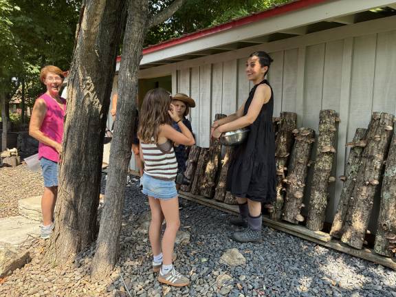 Venjara showing her shiitake logs to visitors on the Dirt Kitchen Garden Tour in July.