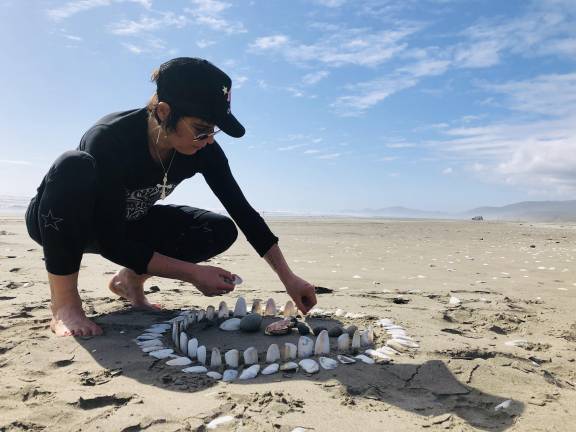 The writer creating a small work of land art on a beach in Chonchi near Palihue, Chile.