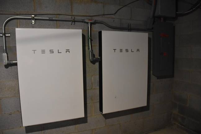 A pair of Tesla Powerwall batteries in the couple's 300-year-old basement store energy from the panels.