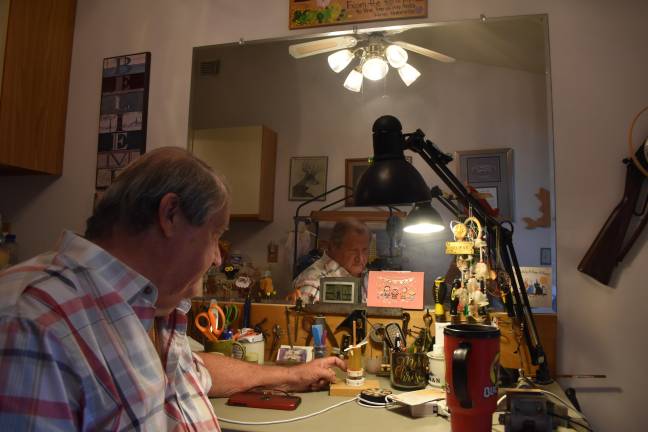 Rossi at his “man cave” in his condo, with a weathervane he made out of an old prescription bottle and a magnet.