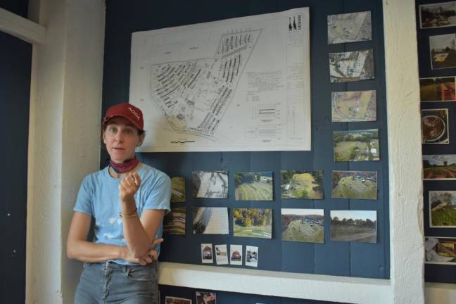Alix, an architect, in front of her farm plans and photos showing how the fields progressed from barren to lush over the past two years.
