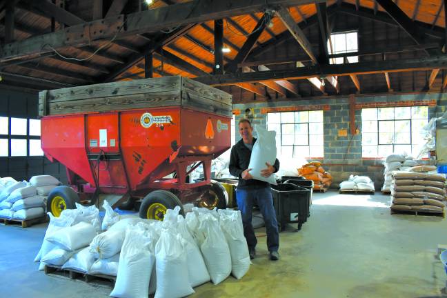 Lenny Bussanich holds a 50-pound sack of wheat in the storage room at Marksboro Mills in Blairstown, NJ.