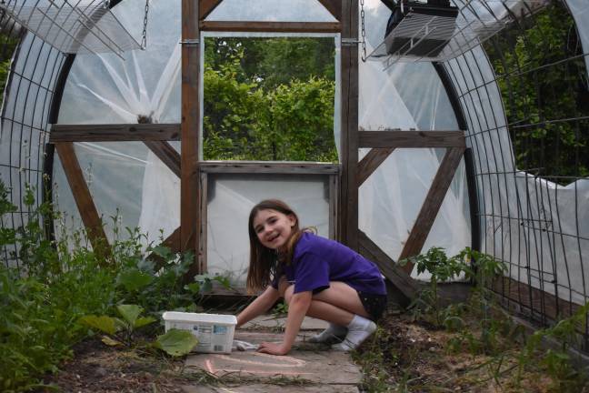 Juno, 9, making chalk art in the hoop house.