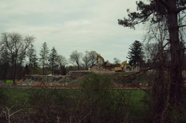 Demolition equipment and a remaining stone wall of the Bennett School.