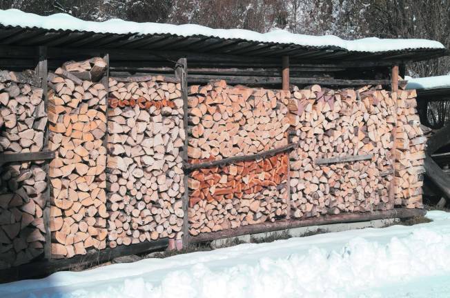 Pile of chopped wood ready for the fireplace with snow