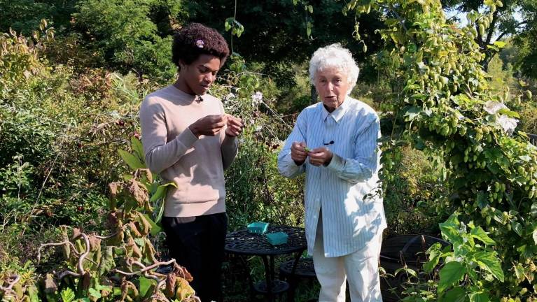 Baker and WPBS special correspondent Yatile Patterson examine hops flowers they just harvested in Baker’s garden.