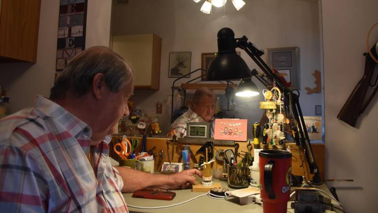 Rossi at his “man cave” in his condo, with a weathervane he made out of an old prescription bottle and a magnet.