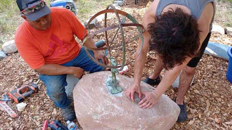 Eagle Scout candidate Leo Portanova works with Mark Olson of M.P. Olson Excavation, who donated his time, equipment and the boulder upon which the sundial is mounted.